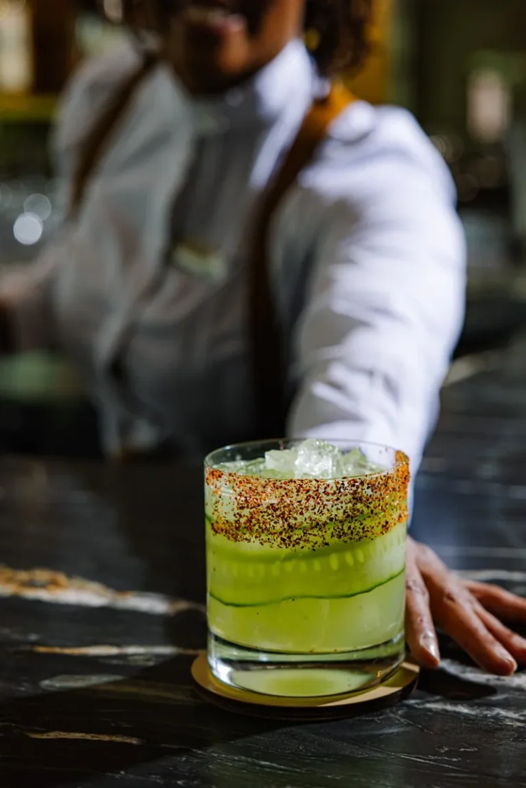 A bartender serving a freshly prepared cocktail
