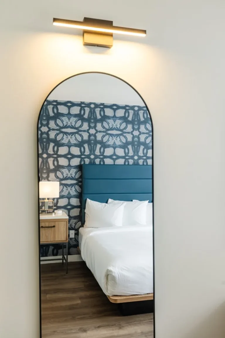 A Hive House guest room reflected in an arched mirror