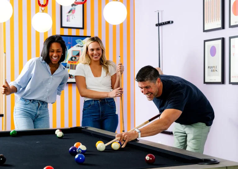 A guest playing pool with friends